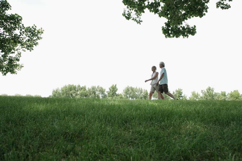 Couple walking green hill