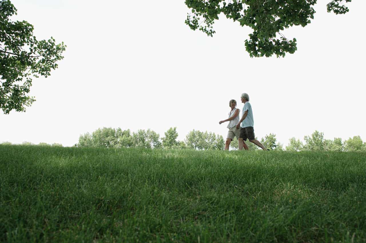 Couple walking green hill