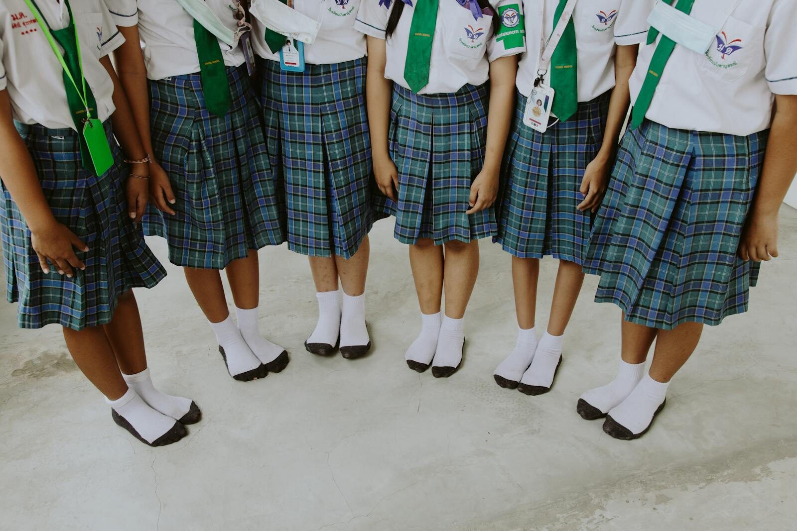 Low angle view of children in school uniforms standing in a row indoors.